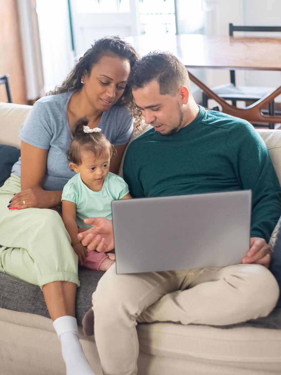 A family watching a laptop together on the sofa